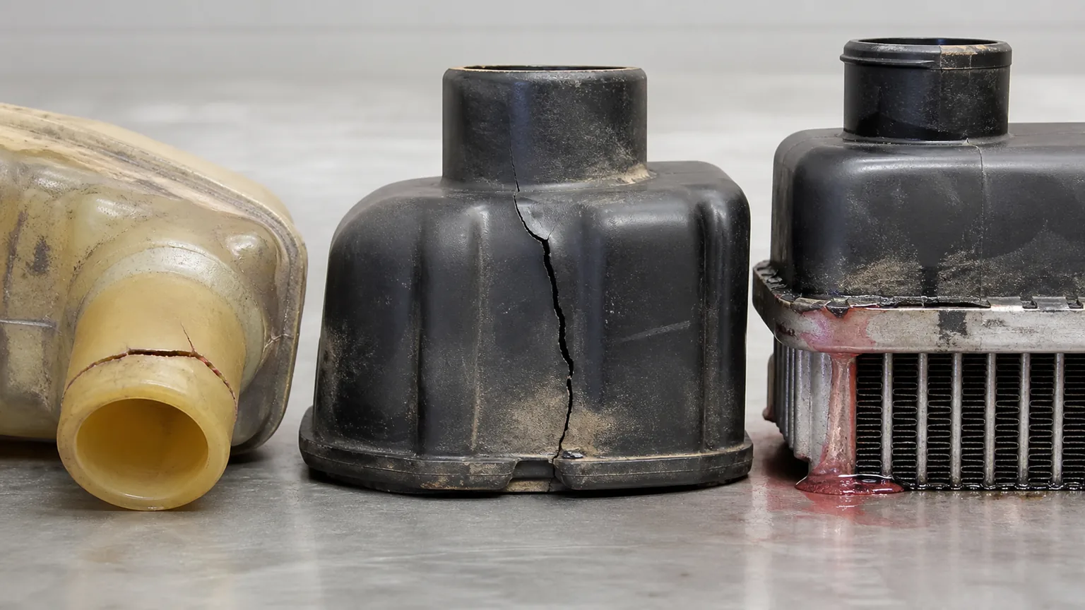 Close comparison of plastic radiator hose neck crack tank crack and tank to header crimp leak