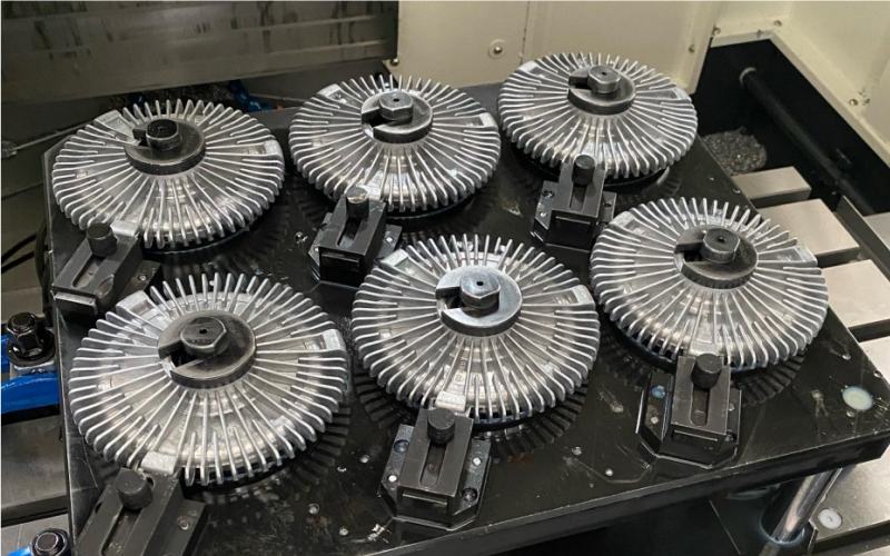 Aftermarket fan clutch samples displayed on factory workbench