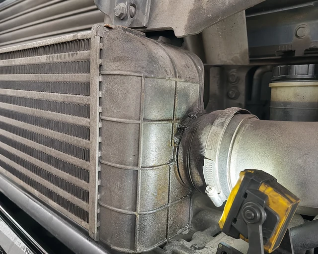 Oil stain around diesel truck charge air cooler end tank seam and pipe connection