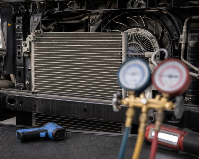 A/C condenser fins and manifold gauges used to diagnose poor low-speed airflow