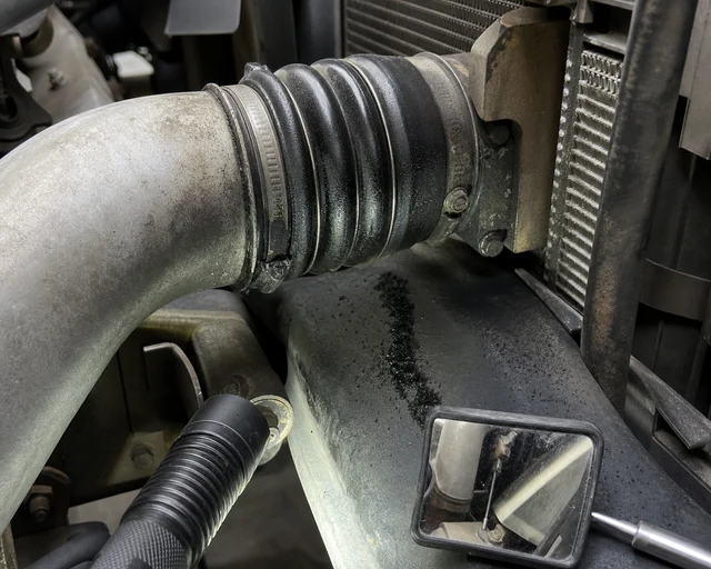 Diesel boost boot connection with oil mist, soot trail, and loose clamp witness mark