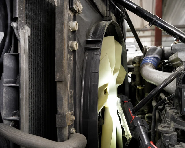 Heavy-duty cooling fan and shroud clearance inspection behind radiator stack