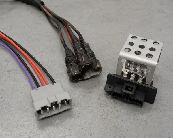 Melted blower motor resistor connector beside a new pigtail and resistor module